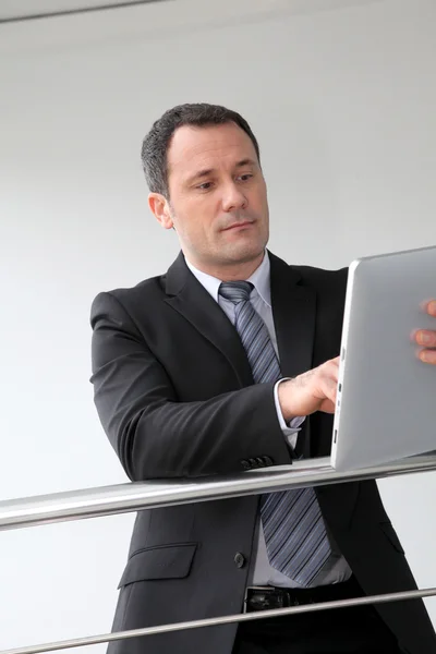 Biznesmen stoi w hali z elektronicznych tabletki — Zdjęcie stockowe