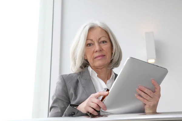 Старша бізнес-леді, використовуючи електронний планшет в залі — стокове фото