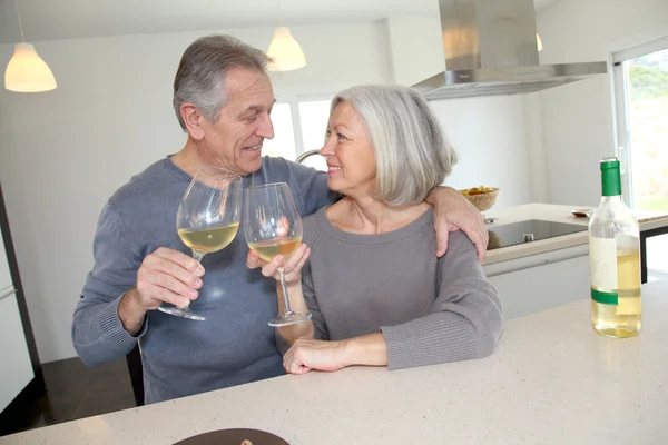 Casal sênior beber vinho em casa cozinha — Fotografia de Stock