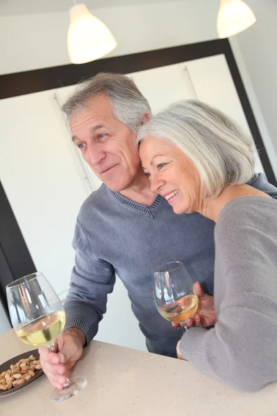 Äldre par som dricker vin i hemmet köket — Stockfoto