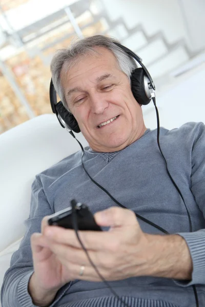 Старший слушает музыку в наушниках — стоковое фото