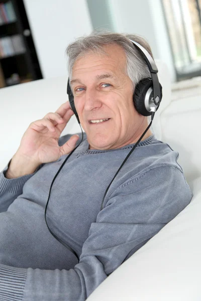 stock image Senior man listening to music with headphones