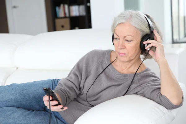 Wanita senior mendengarkan musik dengan headphone — Stok Foto