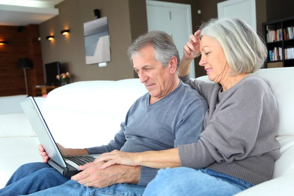 Senior couple surfing on internet at home — Stock Photo, Image
