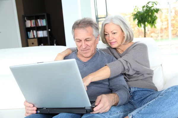 Couple senior surfant sur internet à la maison — Photo