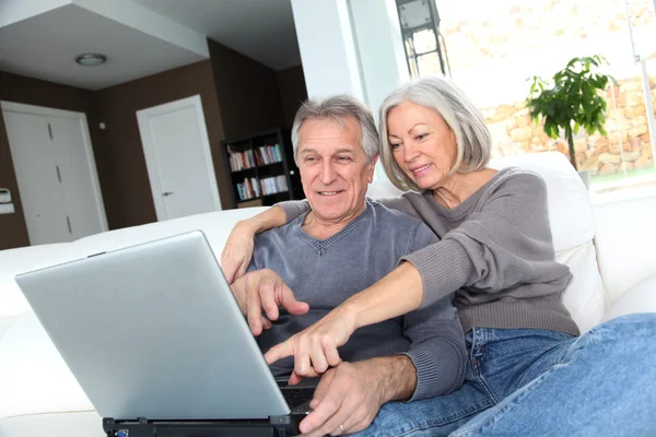 Ανώτερος ζευγάρι σερφάρισμα στο Διαδίκτυο στο σπίτι — Φωτογραφία Αρχείου