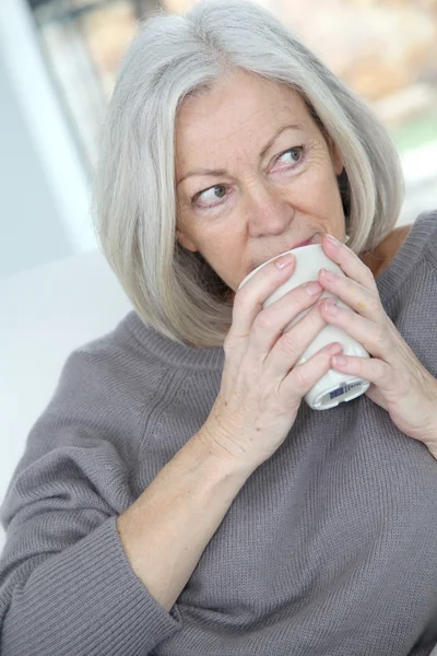 Seniorin trinkt Heißgetränk — Stockfoto
