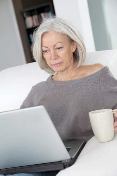 노트북 컴퓨터 앞 집에서 휴식 하는 고위 여자 — 스톡 사진