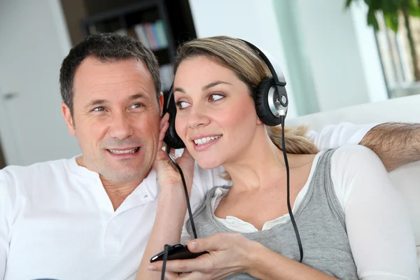 Paar hört Musik mit Kopfhörern — Stockfoto