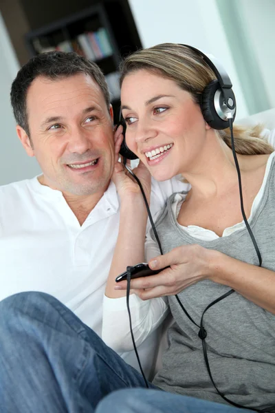 Пара слушающих музыку с наушниками — стоковое фото