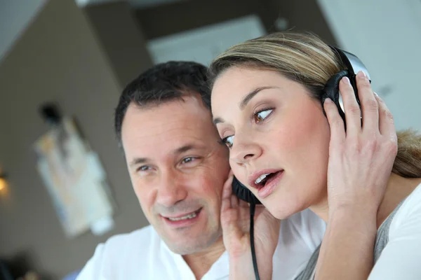 Casal ouvindo música com fones de ouvido — Fotografia de Stock