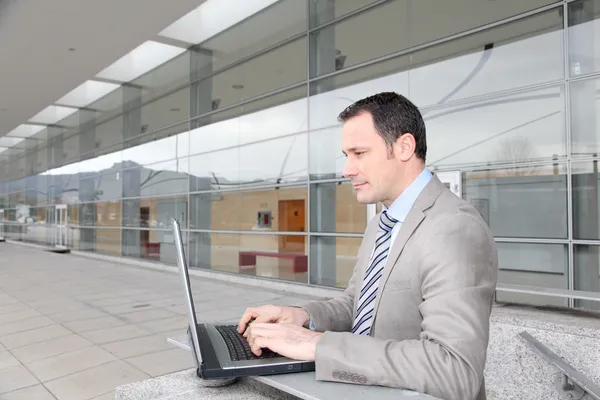 Man in business travel working on laptop computer Royalty Free Stock Images