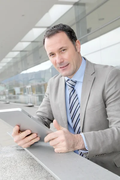 Businessman using electronic tab outside congress center Stock Photo