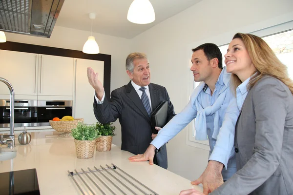 Real estate agent showing modern house to couple Royalty Free Stock Photos
