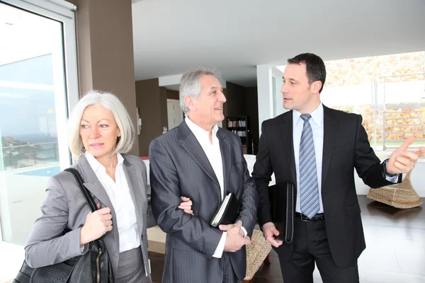 Senior couple visiting modern house with real-estate agent Stock Photo
