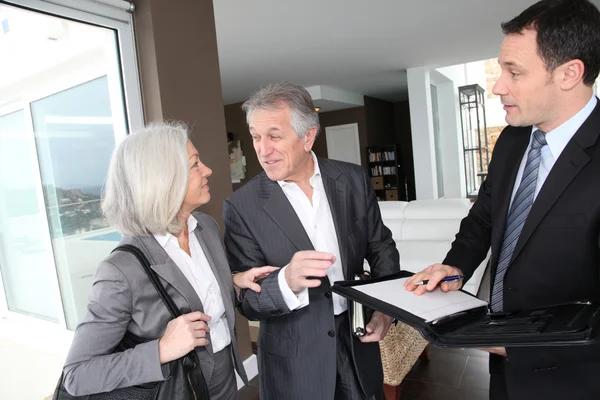 Äldre par underteckna finansiella kontrakt för fastighetsköp — Stockfoto