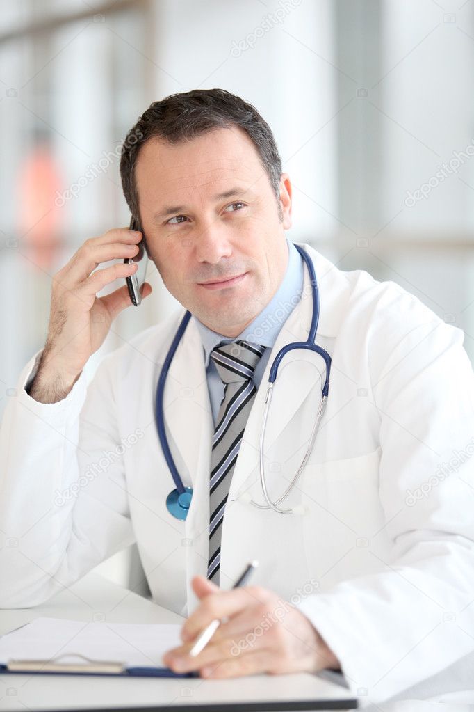 Portrait of handsome doctor talking on the phone