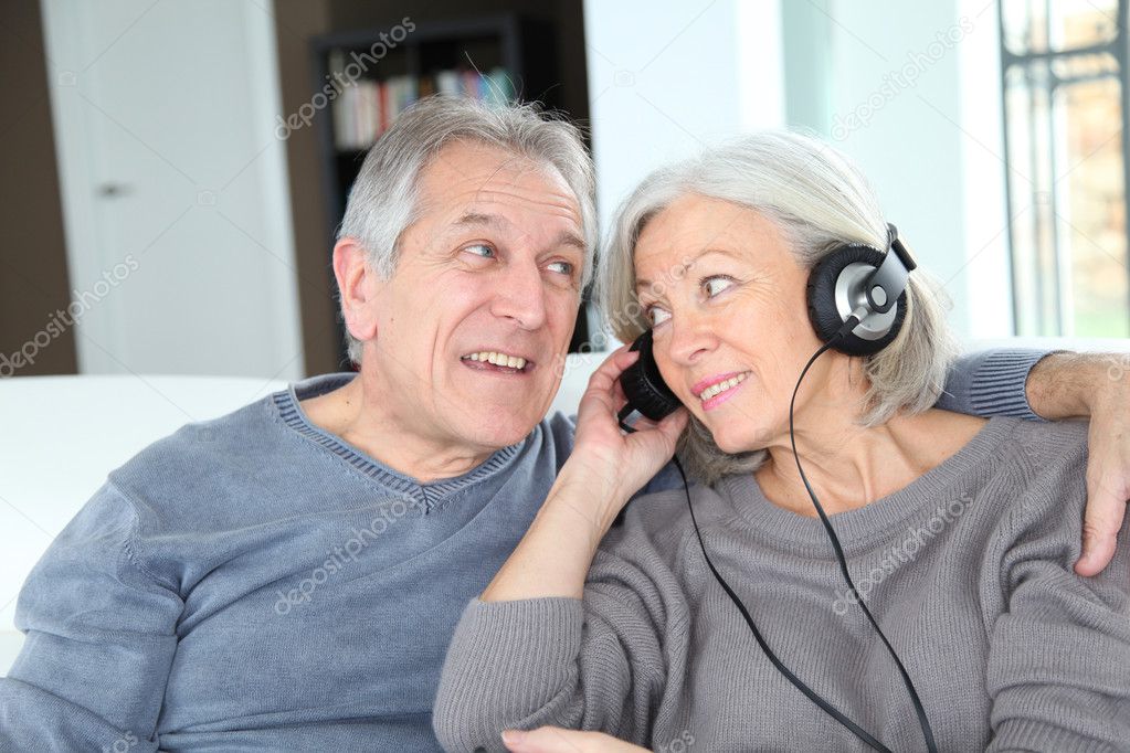 Senior couple listening to music with headphones