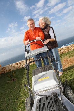 Senior couple mowing the lawn clipart
