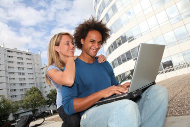 Couple of students working on laptop computer clipart