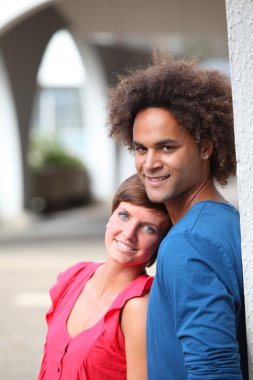 Couple of students standing against a wall clipart