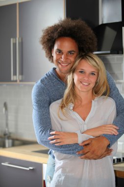 Young couple standing in kitchen clipart