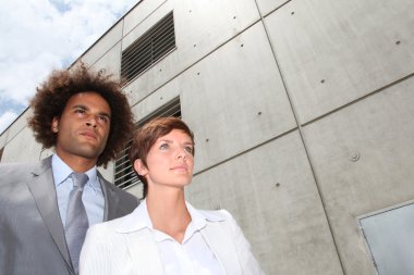 Businesspeople in front of concrete wall clipart