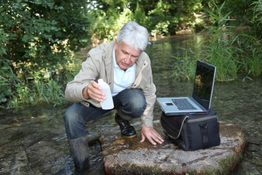 Biologist testing quality of stream water clipart