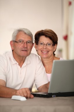 Senior couple with laptop computer clipart