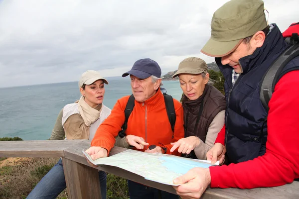 Grupo de olhar para o mapa em um dia de caminhada — Fotografia de Stock