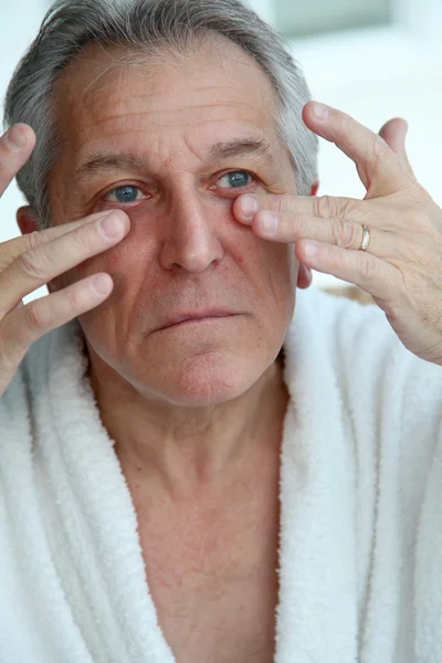 Uomo anziano che fa un massaggio facciale — Foto Stock