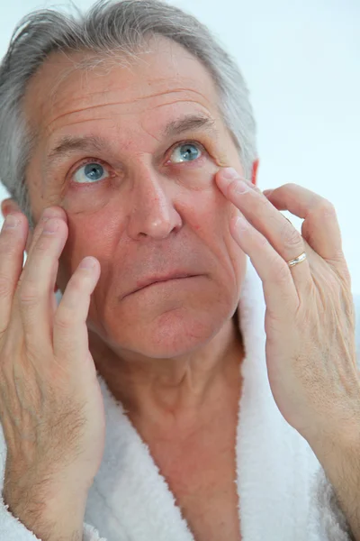 Senior mannen gör en ansiktsmassage — Stockfoto