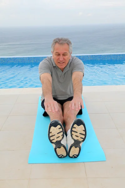 Idősebb ember gyakorolja a medencénél — Stock Fotó