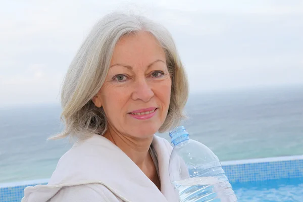 Donna anziana dinking acqua dalla bottiglia — Foto Stock