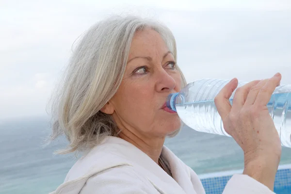 Äldre kvinna dinking vatten från flaska — Stockfoto