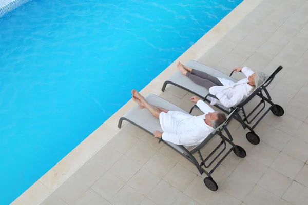Seniorenpaar entspannt in langen Stühlen — Stockfoto