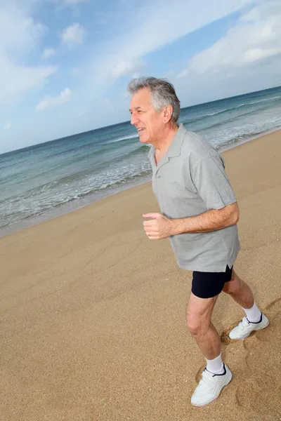 Senior homem correndo na praia — Fotografia de Stock