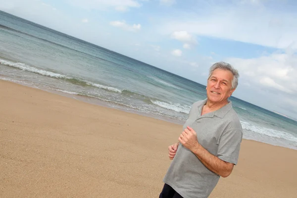 Senior läuft am Strand — Stockfoto