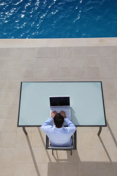 Man computer gebruikt door zwembad — Stockfoto