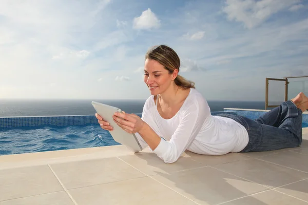 Жінка використовує електронний планшет біля басейну — стокове фото