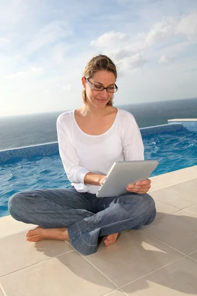 Γυναίκα με τη χρήση ηλεκτρονικών δισκίο από την πισίνα — Φωτογραφία Αρχείου