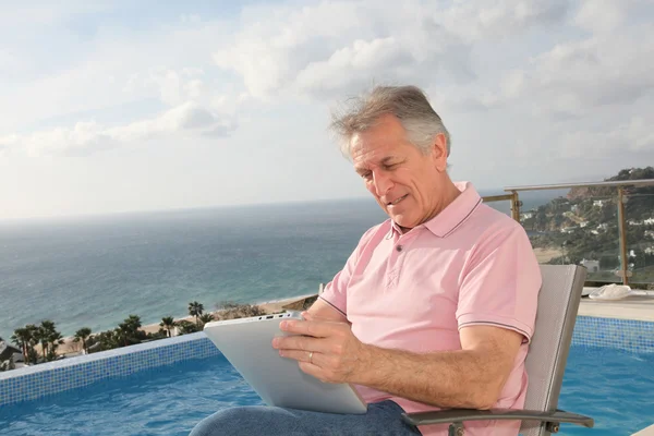 Homme âgé utilisant une tablette électronique — Photo