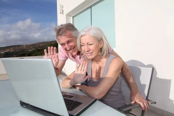 stock image Senior couple waving at webcamera on laptop computer