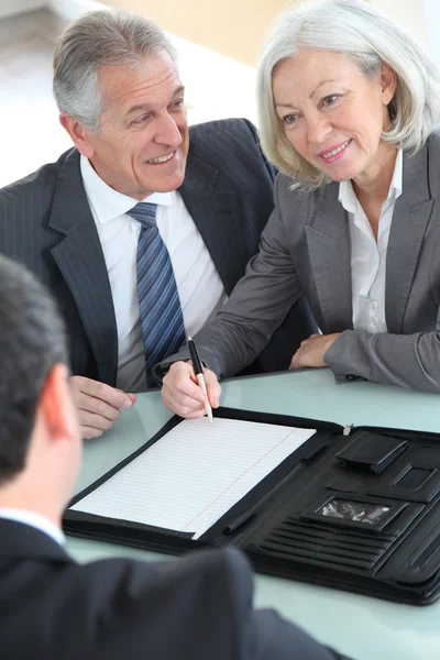 Senior couple signing home purchase contract — Stock Photo, Image