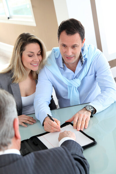 Happy couple signing purchase contract