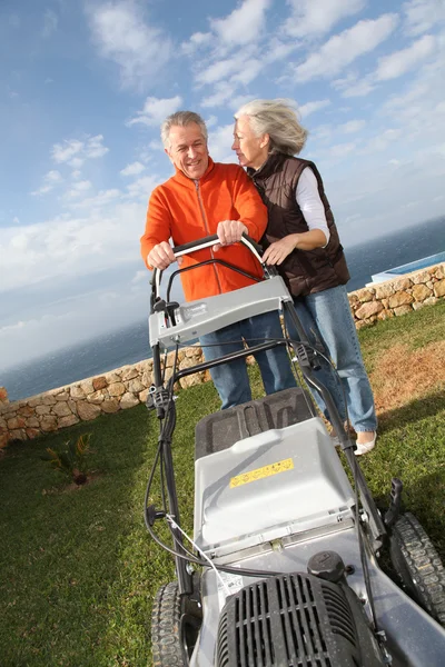 Seniorenpaar mäht den Rasen — Stockfoto