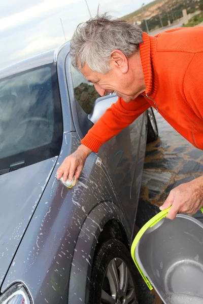 Senior man zijn auto wassen — Stockfoto