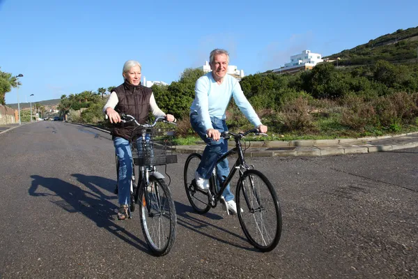 Старша пара їзда на велосипеді — стокове фото