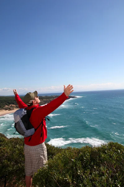 Escursionista che tende le braccia di fronte al mare — Foto Stock