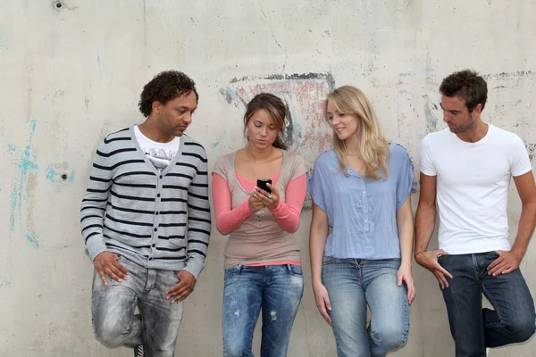 Group of friends standing against wall — Stock Photo, Image